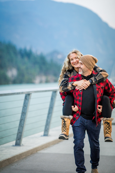 Man giving woman piggyback ride while walking on mountainous overlook