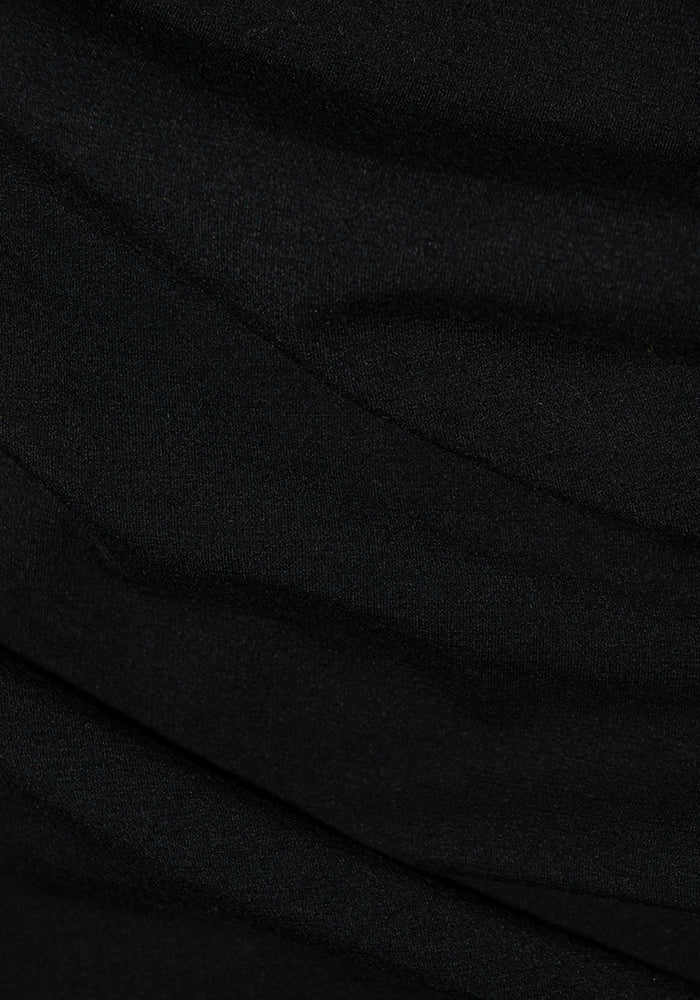 Close-up of the Stella Petite - Black fabric from Woolx, featuring subtle, overlapping folds and a smooth texture. The lighting creates gentle shadows, highlighting the contours and depth of the DuraLite material.