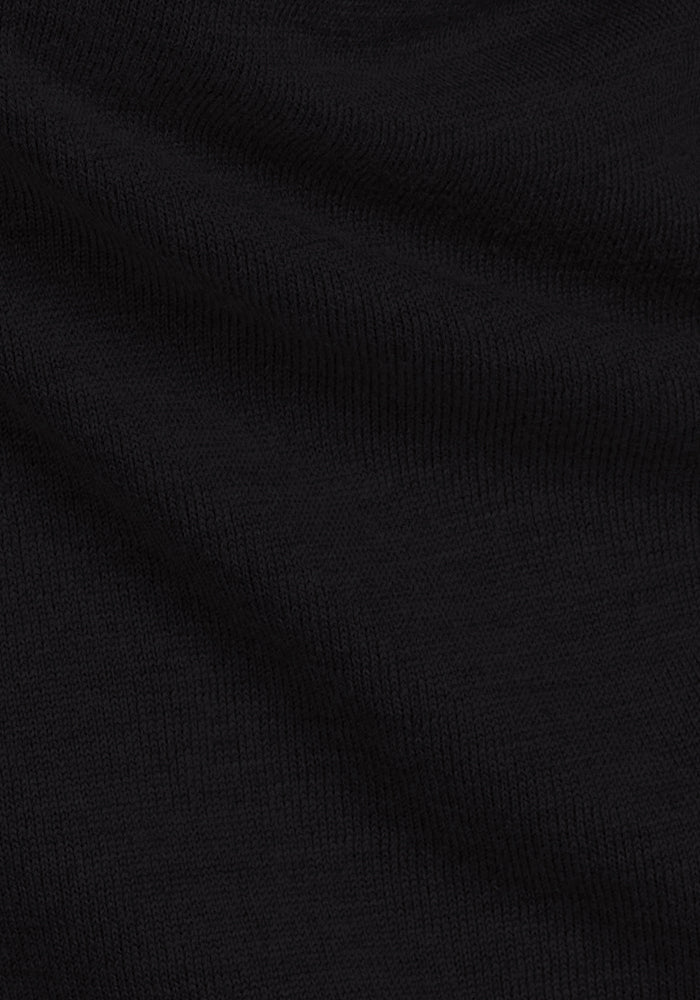 Close-up of the Woolx Anna Crew Sweater in black, featuring a textured, ribbed merino wool knit with subtle folds and shadows.