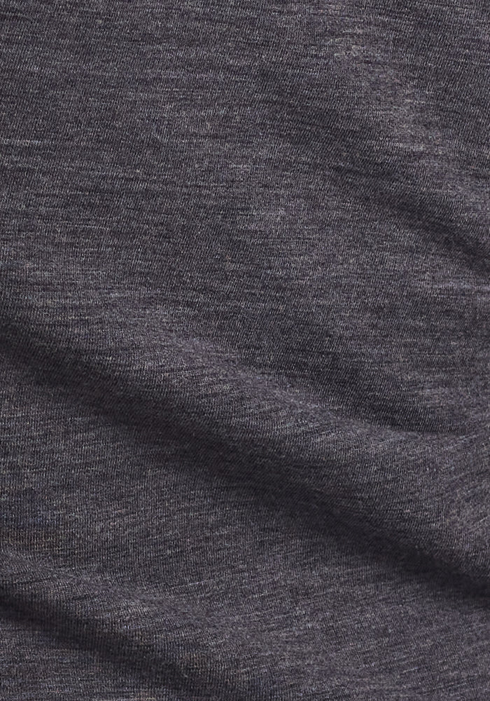 A close-up of soft, dark gray heathered fabric with gentle folds, perfect for the Woolx Ellie Wide Leg Pants - Cinder Melange, a cozy Merino wool option to replace your favorite warm pants.