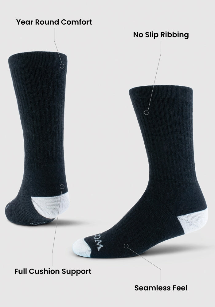 The Woolx Core Crew Socks Full Cushion - Black are shown from side and back, featuring white heels and toes. Labels highlight year-round comfort, odor-resistant fibers, no-slip ribbing, full cushion support, and a seamless feel.