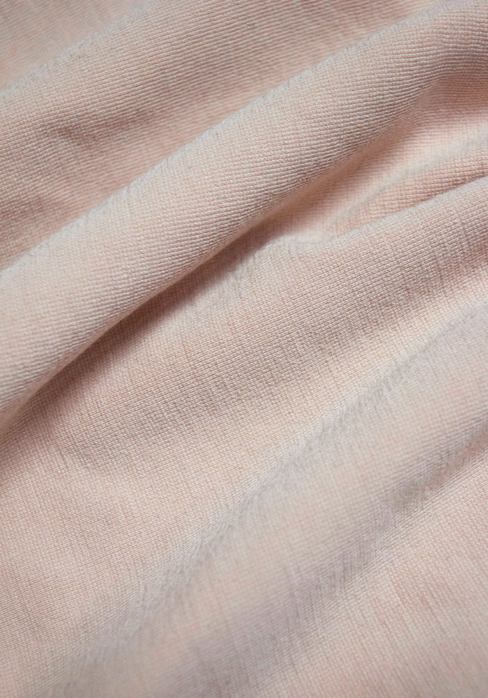 Close-up of soft, textured light beige merino wool fabric with gentle folds and subtle shadows—perfect for seamless construction, as featured in the Woolx Hayden Bra - Sand.