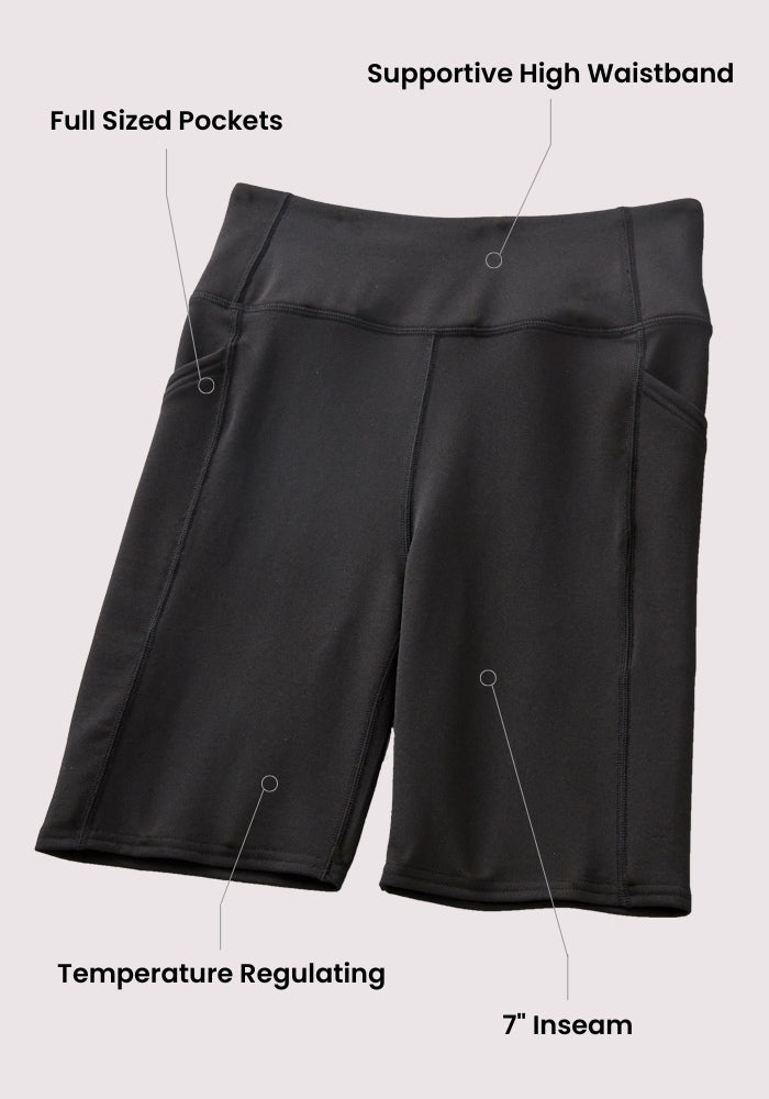 The Woolx Merino Flex® Dani Bike Shorts in Majolica Blue feature a supportive high waistband, full-sized pockets, moisture-wicking and temperature-regulating fabric, and a 7-inch inseam. Text labels highlight each feature on the shorts.