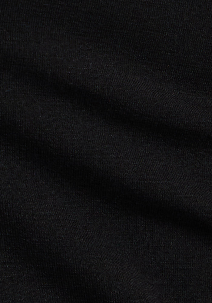 Close-up of black, soft-textured fabric with subtle horizontal folds. The smooth, slightly ribbed knit cotton indicates premium comfort—ideal for Woolx Madden Joggers - Black.
