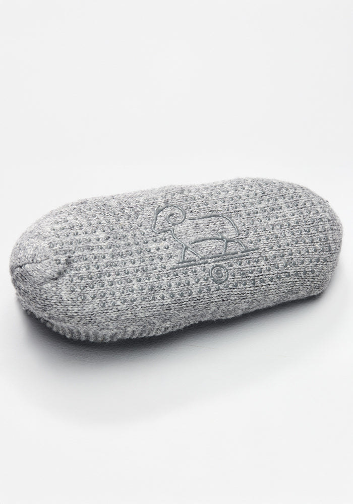 A gray, textured oval soap bar etched with a bird on a skateboard, echoing the playful design seen on Woolx Womens Gripper Slippers - Gentle Grey, is displayed against a white background.