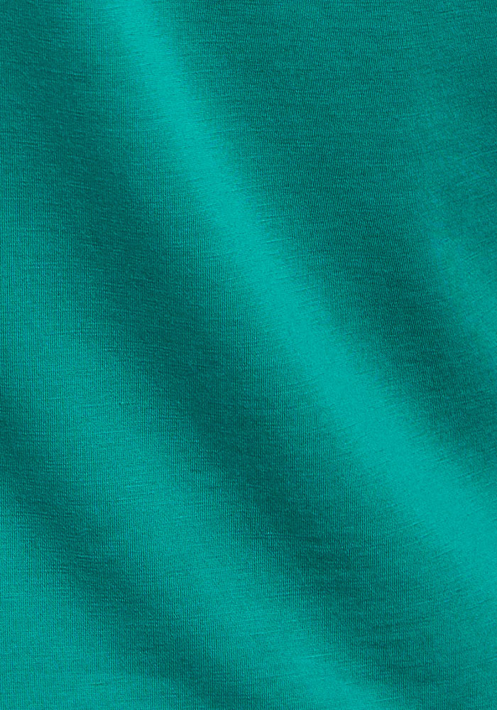 Close-up of Bella Tunic Top - Cabana Crush by Woolx, showing its smooth teal fabric with gentle folds and subtle shadows.