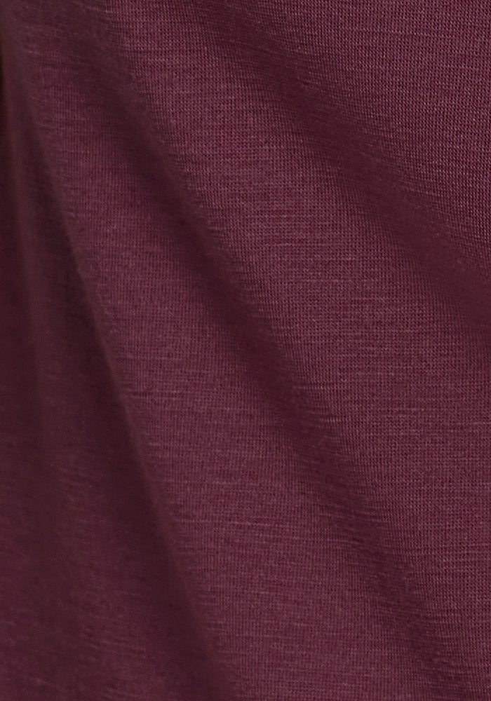 Close-up of Woolx Millie Long Sleeve in Grape Harvest, showing textured Merino wool with a slight diagonal crease.