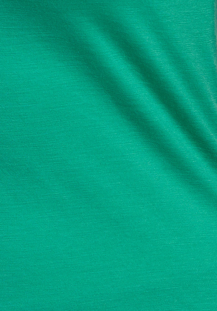 The Woolx Mia V Neck - Jungle features green moisture-wicking fabric with a subtle diagonal wrinkle and visible weave.