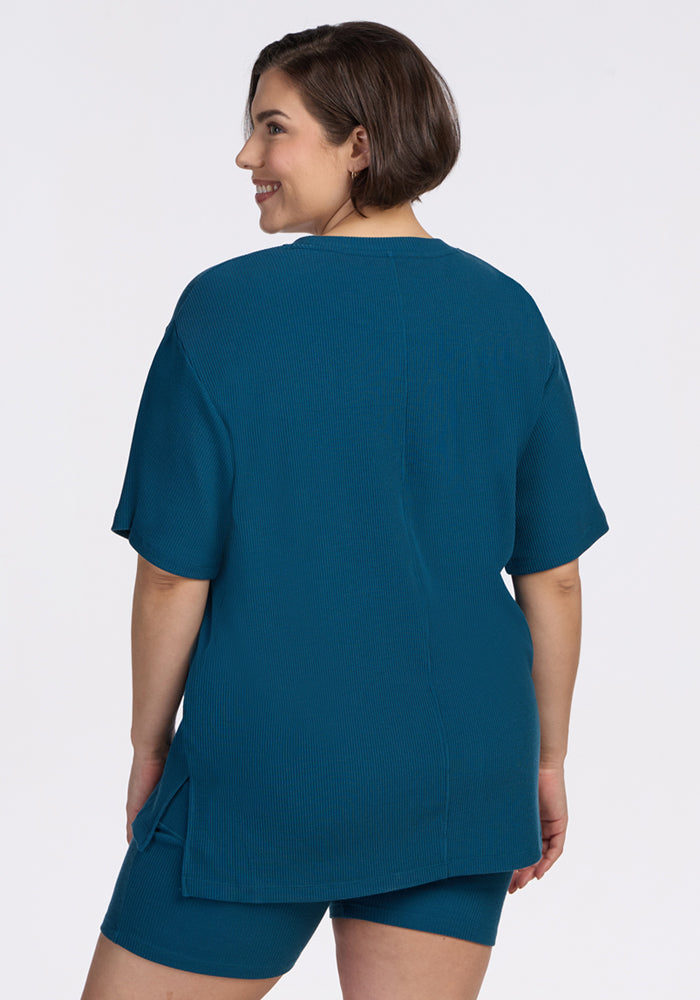 Woman smiling in the Woolx Vera Ribbed Tunic in Moroccan Blue, paired with matching shorts. Final Sale.