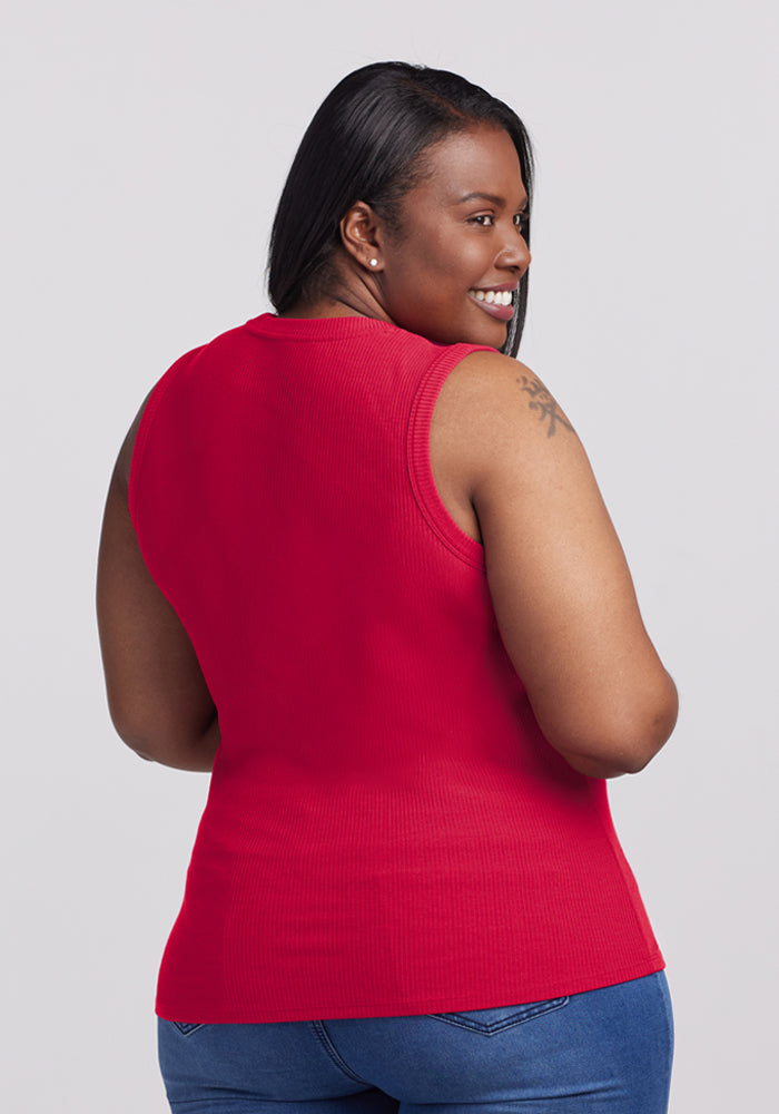 Woman smiling, back to camera, in blue jeans and a Woolx Sloane Ribbed Tank in Poppy Spark.
