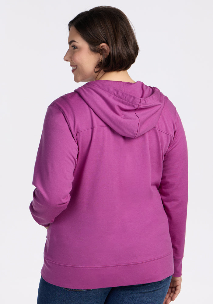 Woman with short brown hair smiles over her shoulder in a Woolx Ryann Hoodie • Final Sale - Purple Wine.