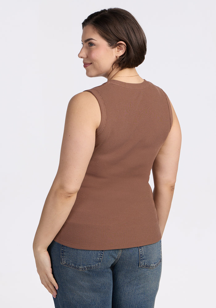 Woman with short brown hair wears the Woolx Sloane Ribbed Tank in Sienna Kiss and blue jeans, facing away and smiling.