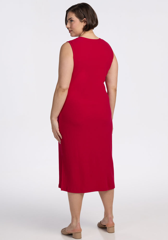 Woman with short brown hair wears the Woolx Iris Ribbed Dress in Poppy Spark, standing with her back to the camera.