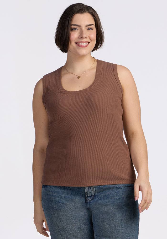 A smiling woman with short brown hair wears the Woolx Sloane Ribbed Tank in Sienna Kiss and blue jeans.