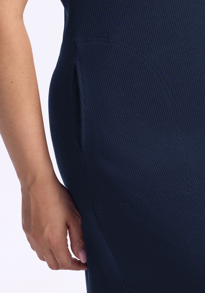 Close-up of a hand by the hip of the Woolx Harlowe Ribbed Dress in Deep Navy, made from temperature-regulating merino wool.
