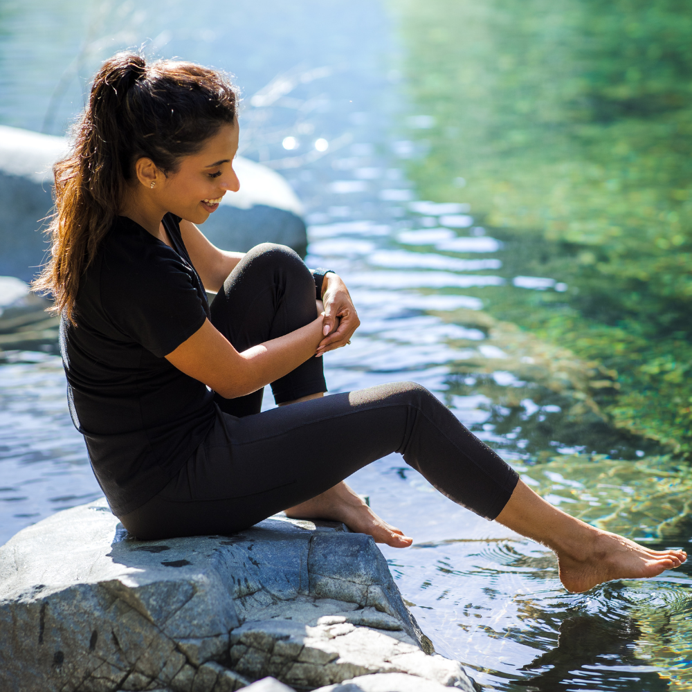 Woman dipping her foot in water wearing mckenna capris