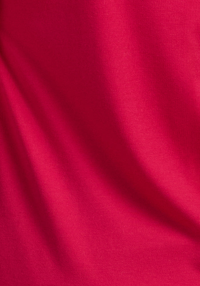A close-up of Woolx Cassie Dress in Poppy Spark, showing soft Merino wool folds and textured shadows.