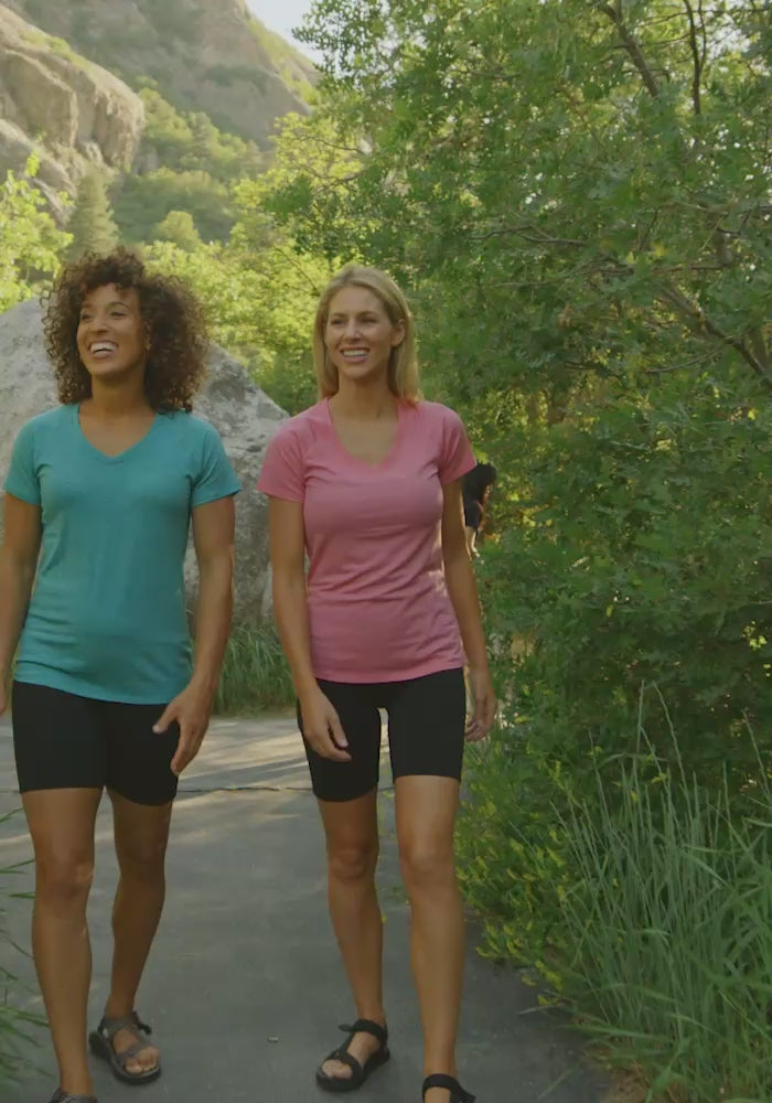 Two models walking through the woods wearing Mia tee