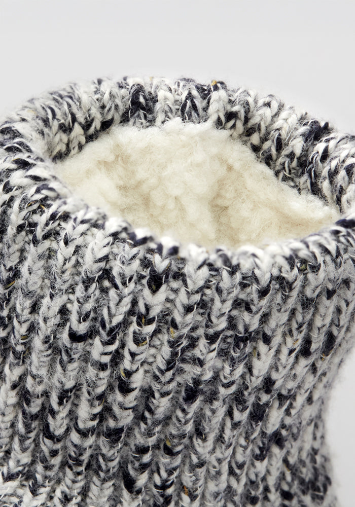 Close-up of the Women's Gripper Slipper Booties - Speckled Stone by Woolx, showing thick black, white, and grey knit with a soft cream lining—ideal cozy slipper socks for comfort and warmth.