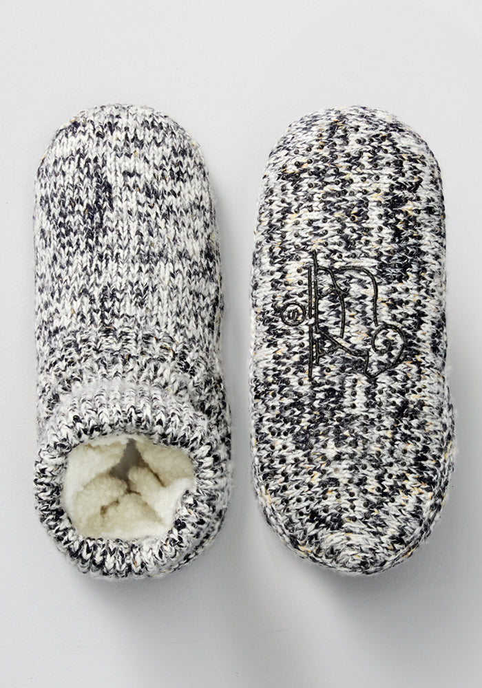 Woolx Women's Gripper Slipper Booties in Speckled Stone: cozy, knitted gray and white Merino wool slippers with soft, fluffy lining. One slipper shows the opening; the other displays the sole's decorative black design.