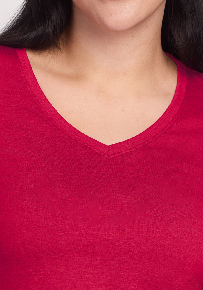 Close-up of a person wearing the Woolx Millie Long Sleeve in Poppy Spark, showing neck, shoulders, and part of face.