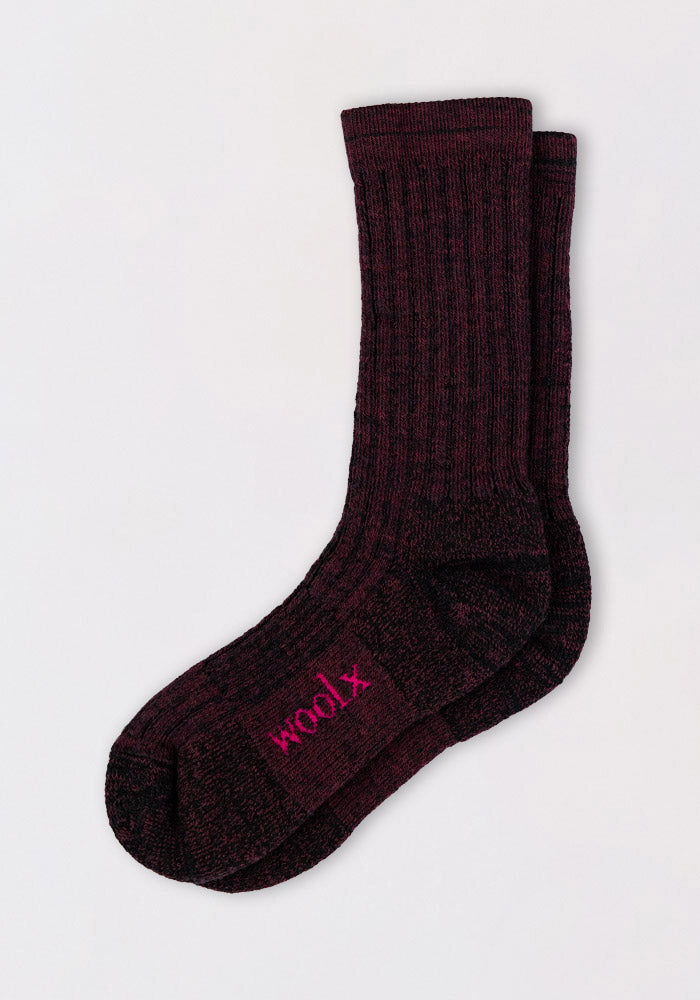 A pair of Womens Joey Crew Socks in Warm Violet by Woolx lie flat on a light background, with "woolx" stitched in pink near the toe, highlighting their cozy, ribbed merino wool crew sock style.
