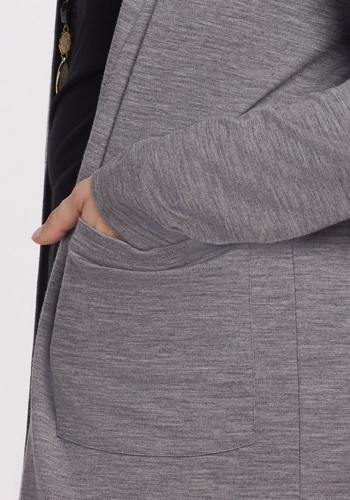A person wearing a Woolx Paisley Cardigan in Graphite Heather, renowned for its feather-light comfort, tucks their right hand into the pocket against a plain white background.