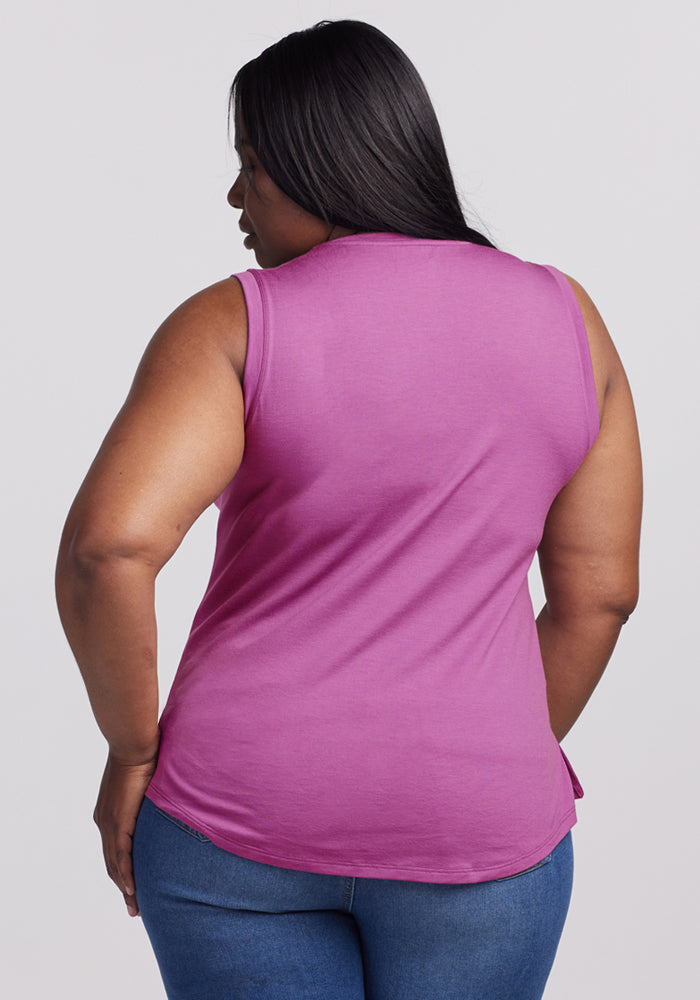 Woman with long dark hair in a Woolx Bella Tunic Top in Purple Wine and blue jeans, shown from the back.