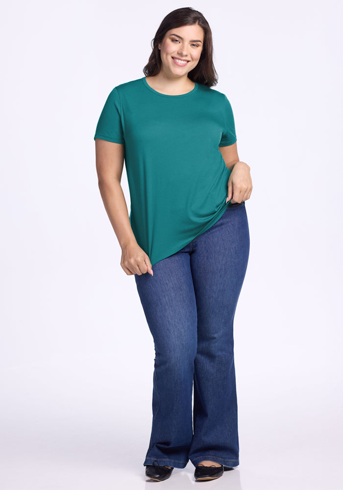 Smiling woman in a Woolx Liza Crew Neck Tee • Final Sale - Surfside, standing against a white background.